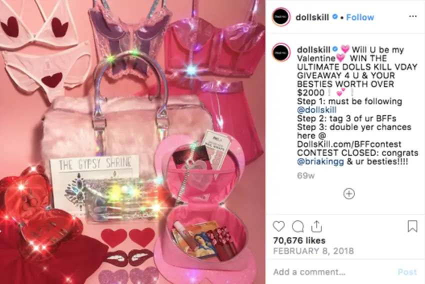 Screenshot of a Dolls Kill Instagram post. The image shows a collection of pink lingerie, accessories, and cosmetics. The caption invites users to a Valentine's Day giveaway worth over $2000. Users have to follow and tag friends to enter.