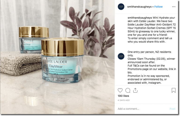Many malls on Instagram run comment giveaways. In this example, the photo shows two jars of Estée Lauder Daywear cream on a marble countertop, next to a face towel. The caption describes how users can comment and share who they would share this prize with, for a chance to win.