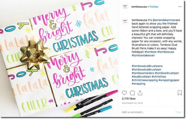 Screenshot of a Tombow USA post on Instagram around Christmastime. The image shows a present wrapped with colorful Christmas paper and a gold ribbon, next to the marker pens used to create the wrapping.